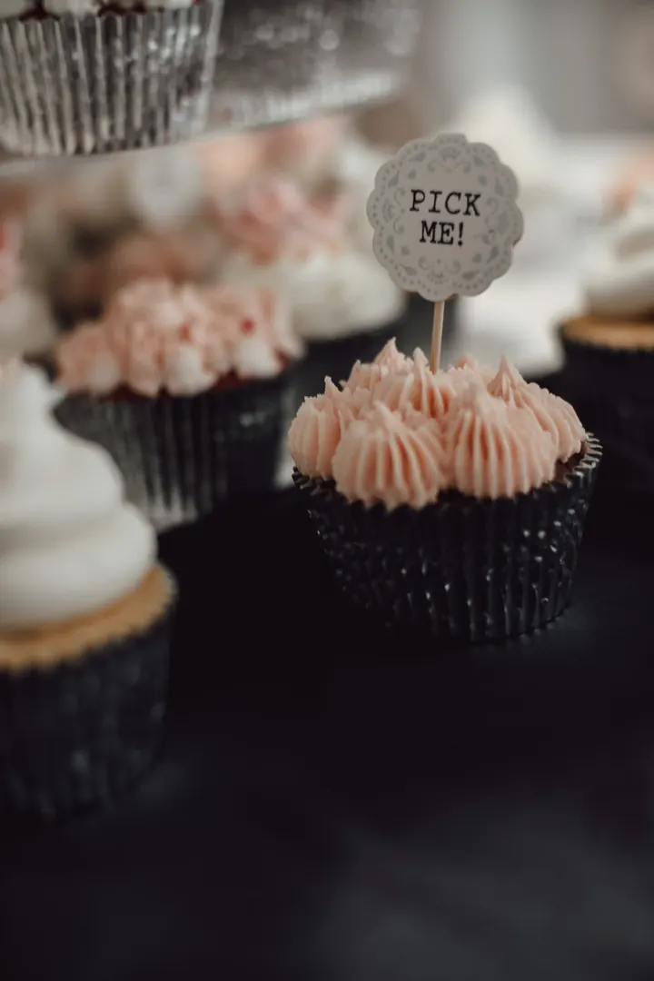 A cupcake with blush icing and a Pick me topper