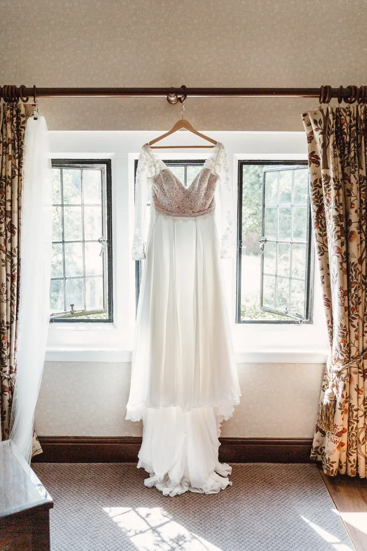 Sarah&rsquo;s lace wedding dress hanging in the window