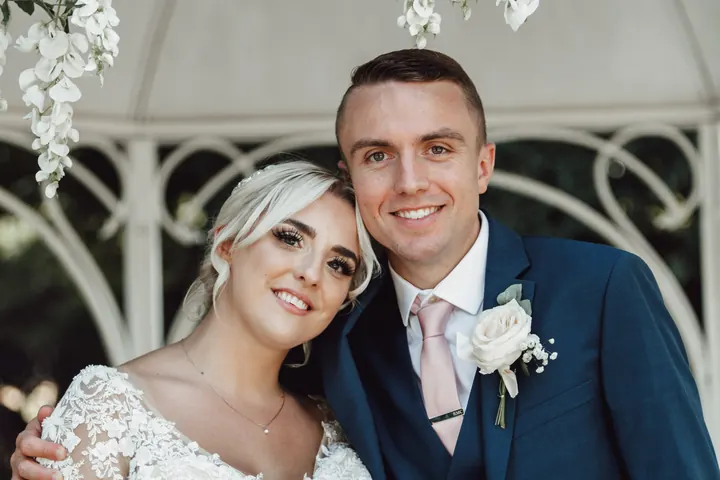 Sarah and Sam cheek to cheek under the gazebo