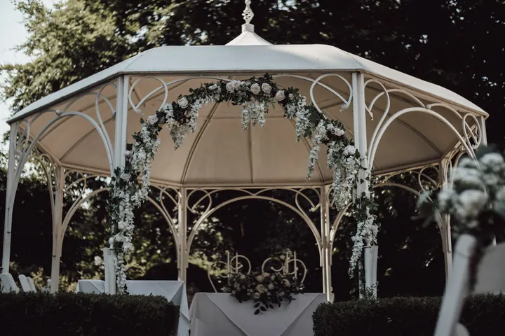 The white garden gazebo dressed with roses and eucalyptus