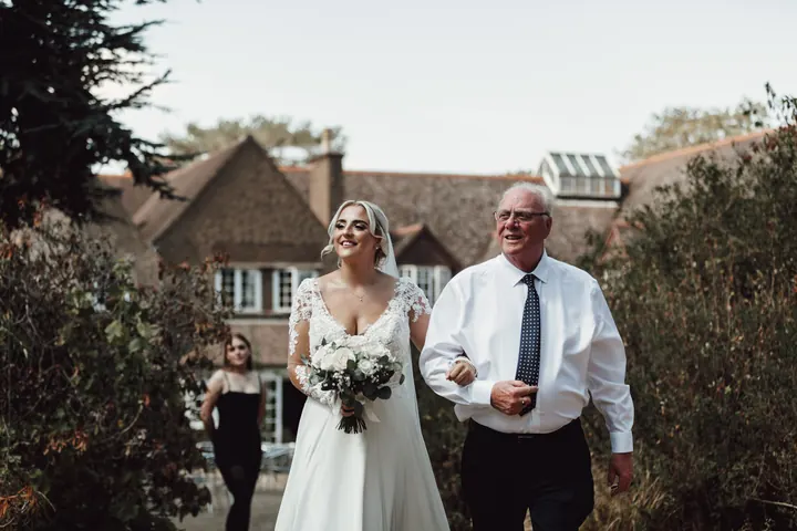 Sarah and her grandad walking through the gardens to the ceremony