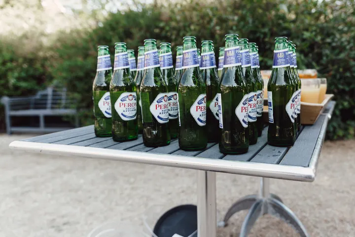 Bottles of Peroni lined up on a garden table