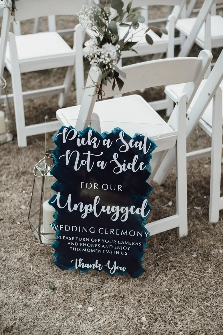 A sign reading Pick a seat not a side for our unplugged wedding ceremony