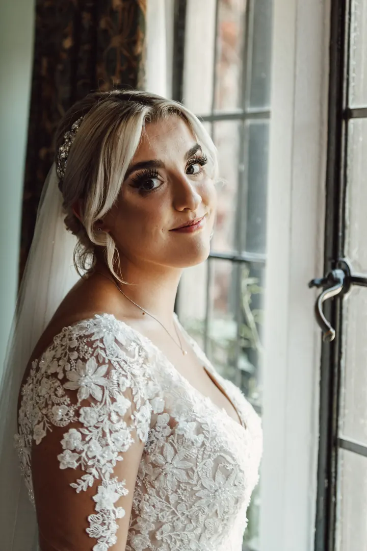 Sarah in her lace dress by the leaded window