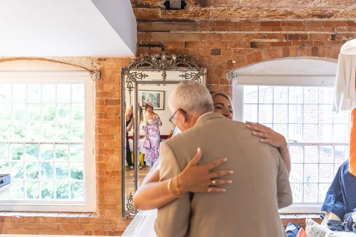 A father hugging his daughter when he sees her in her dress