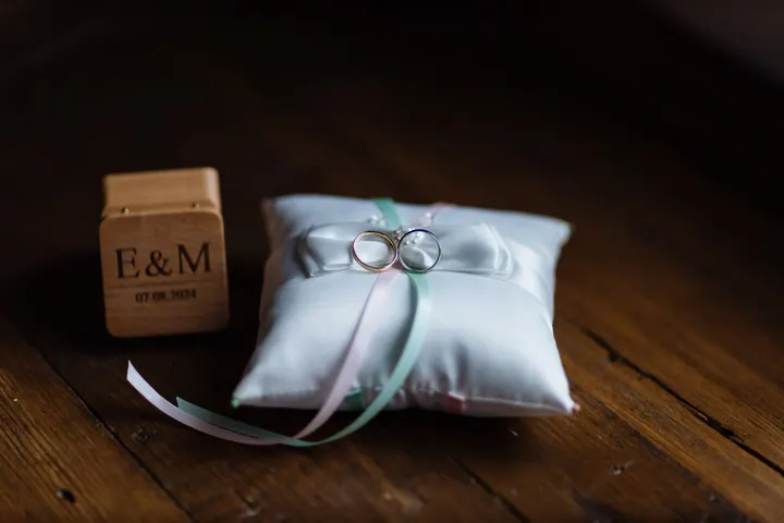 A ring cushion beside a wooden E&M block on a dark floorboard
