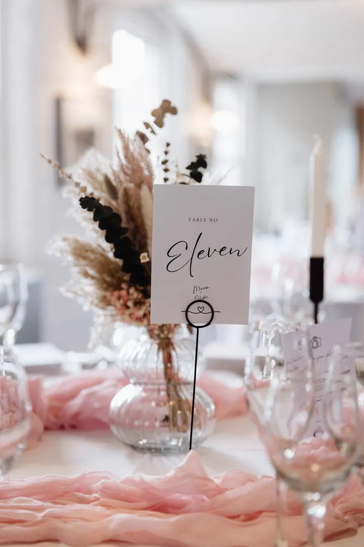 A table name with dried pampas and blush ribbon