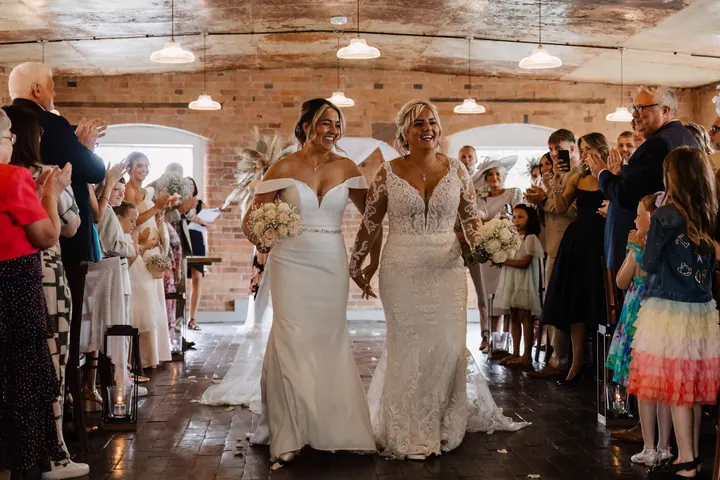 The newlyweds walking back down the aisle past cheering guests