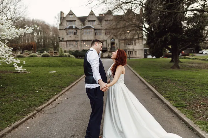 The couple on the long drive with the hall behind them