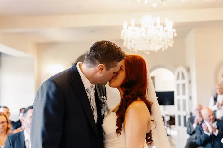 The first kiss in the chandelier-lit ceremony room