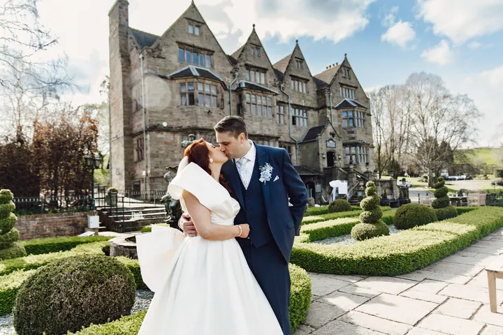 Laura and Darren in the formal gardens with the hall behind