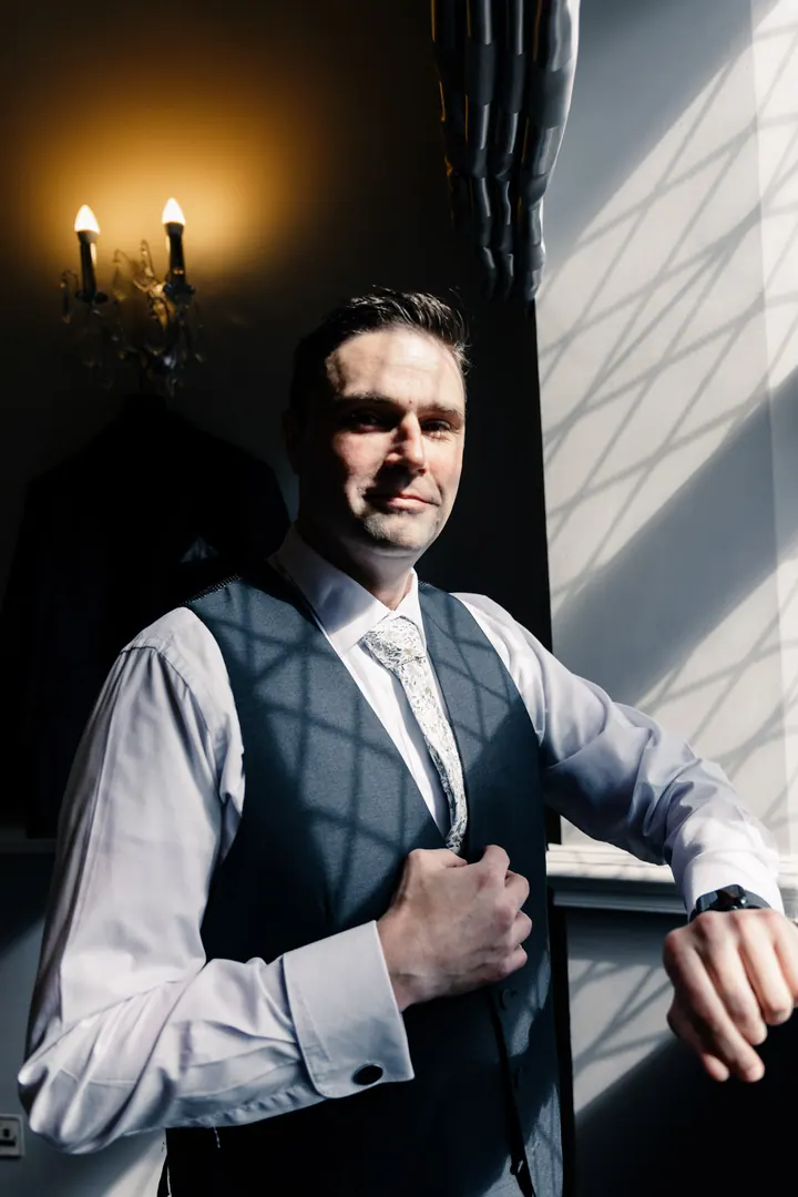 Darren in his waistcoat by a dark window