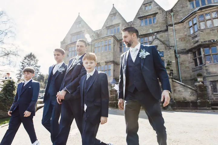 Darren and his groomsmen walking in front of the hall