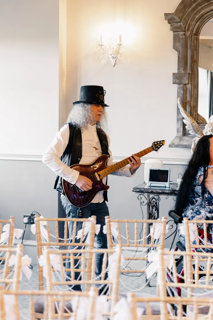 A guitarist in a top hat playing during the ceremony