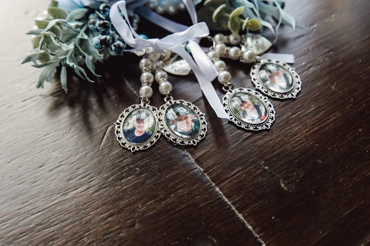 Small photo charms for the bouquet on a dark wooden table