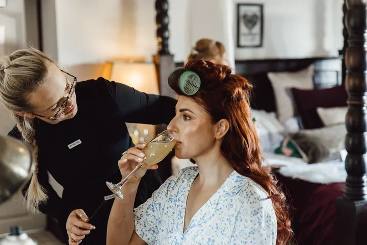 Laura sipping prosecco while her make-up is done
