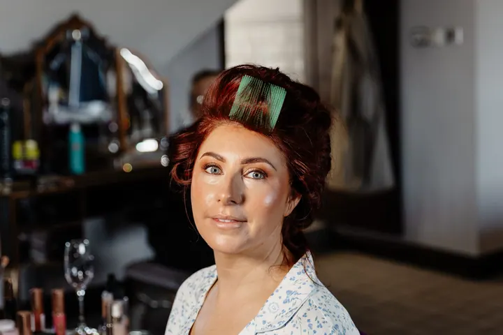 Laura in rollers, gazing out of the window while getting ready