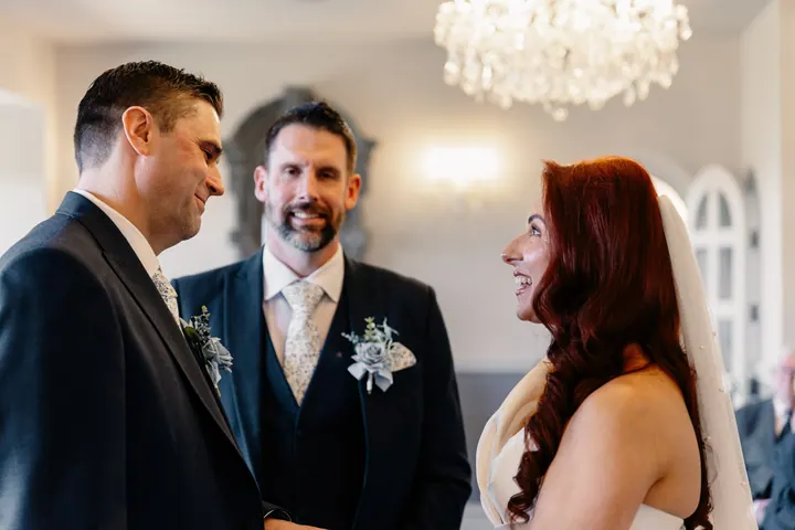 Laura and Darren smiling at each other during the vows